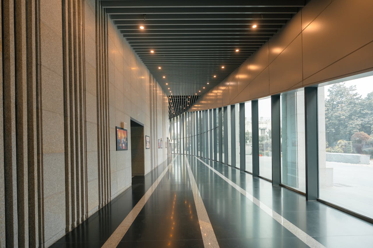 A sleek and modern interior corridor with large windows and sleek lines, suggesting luxury and corporate elegance.